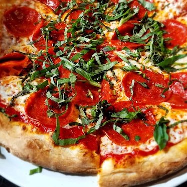 Pizza with pepperoni and basil